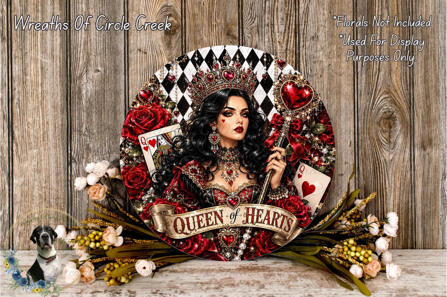 A wreath featuring a woman wearing a crown and holding a heart-shaped object, surrounded by red roses and greenery. The wreath has the text "Queen of Hearts" written on it.