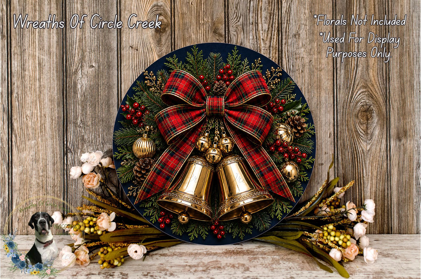 A festive Christmas wreath with a red and black plaid bow, bells, pine cones, and berries, displayed on a wooden surface.
