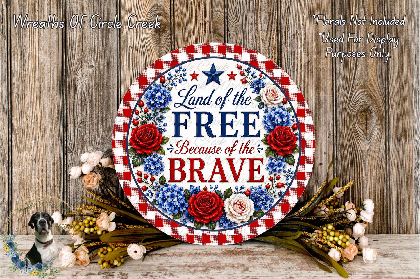 a patriotic sign with the text "Land of the FREE Because of the BRAVE" surrounded by a floral arrangement and a wooden background.