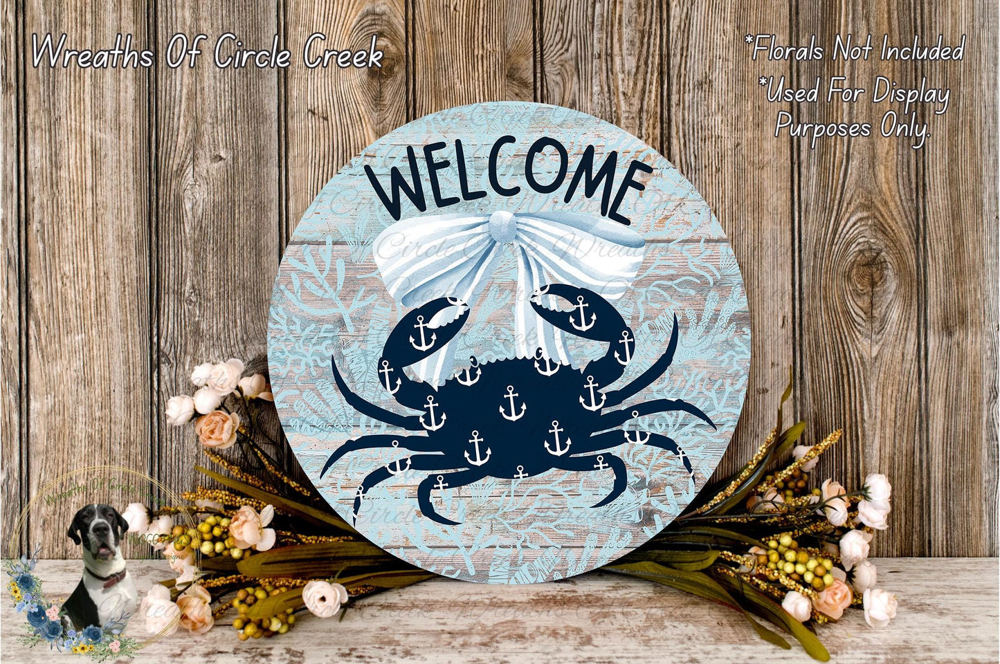 a circular welcome sign with a blue and white color scheme, surrounded by a floral arrangement and a wooden background.