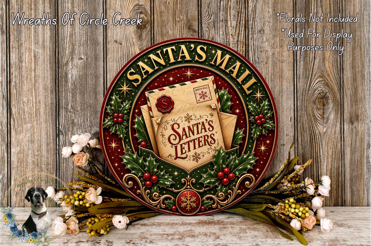 A decorative Santa's Mail wreath with a letter and a small Santa's letter, surrounded by flowers and greenery, against a wooden background.