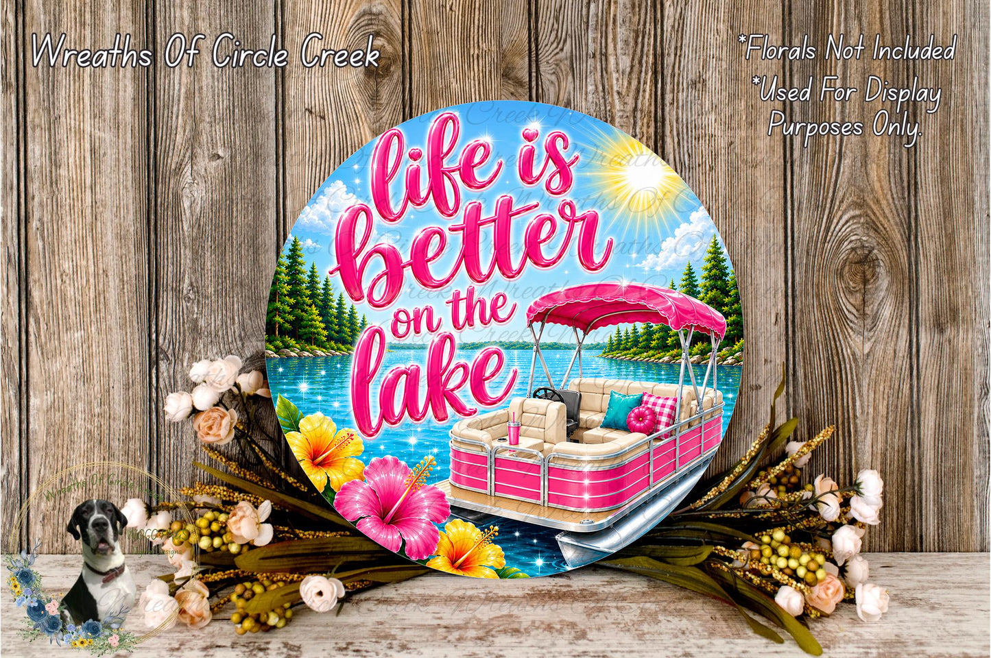 A decorative sign with the text "Life is better on the lake" and an illustration of a boat on a lake surrounded by flowers and a sunny sky.