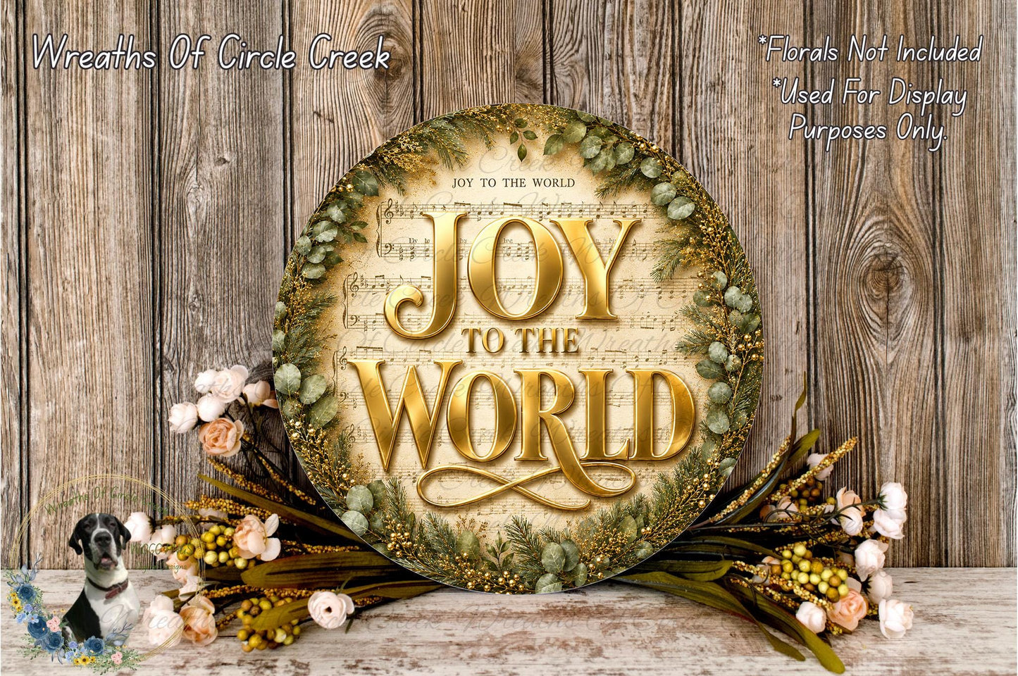 a large, ornate wreath with the text "Joy to the World" displayed on it, surrounded by a wreath of flowers and greenery. The wreath is placed on a wooden surface, and there is a small bird image in the bottom left corner.