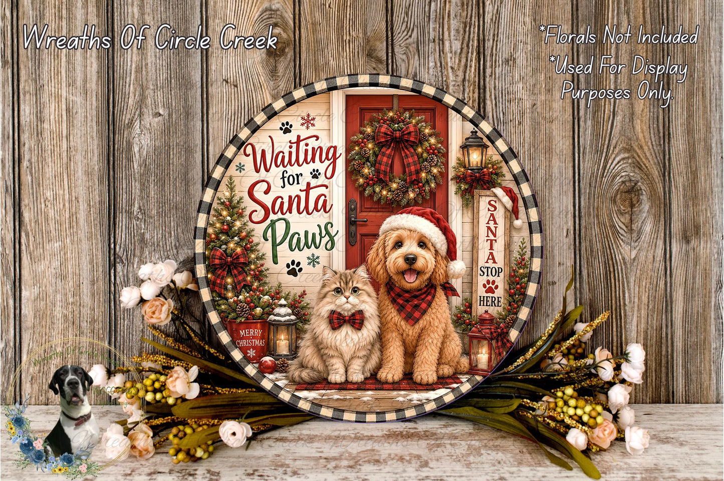 A decorative plate featuring a dog and a cat, with a Christmas wreath and other holiday-themed elements, placed on a wooden surface.