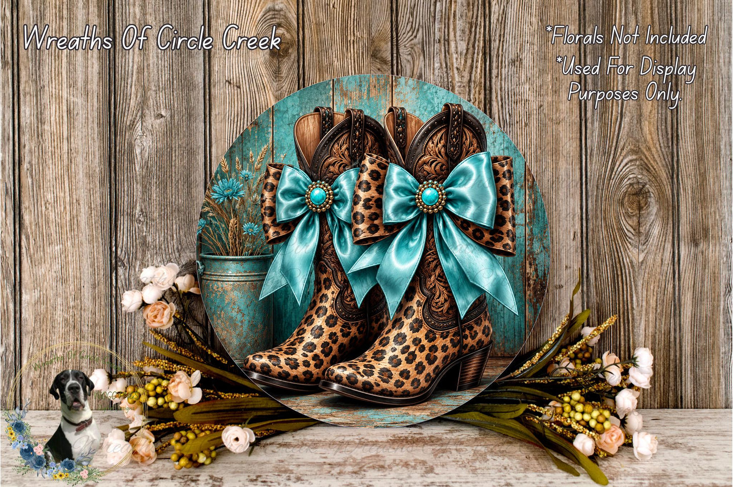 A pair of leopard-print cowboy boots with blue bows, placed on a wooden surface surrounded by flowers and greenery.