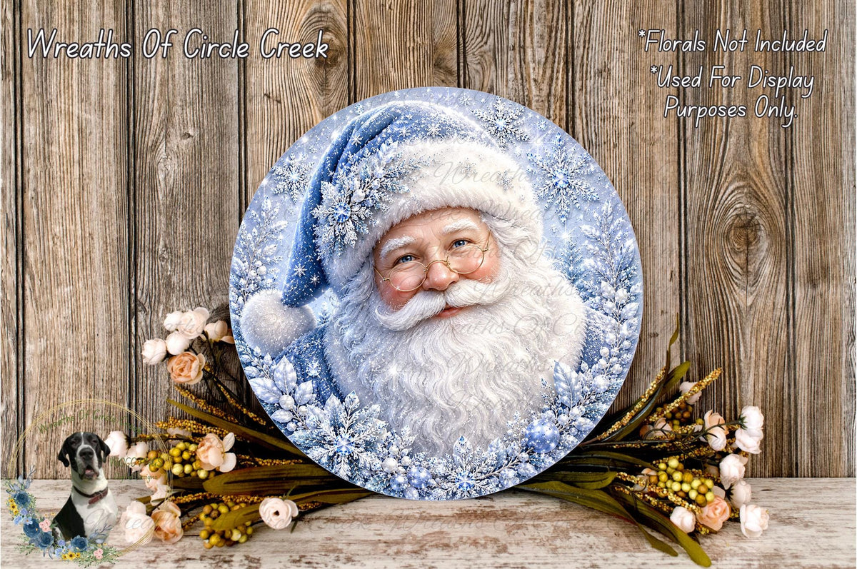A round, decorative plate featuring a painted image of Santa Claus wearing a snow hat, surrounded by snowflakes and flowers, placed on a wooden surface.