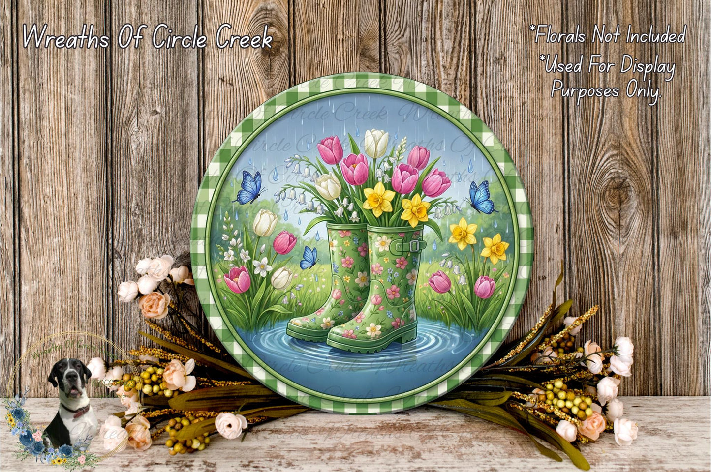 A round, green-rimmed plate with a painting of a pair of rain boots filled with colorful flowers, including tulips, daffodils, and lilies, set against a backdrop of a pond and lush greenery.