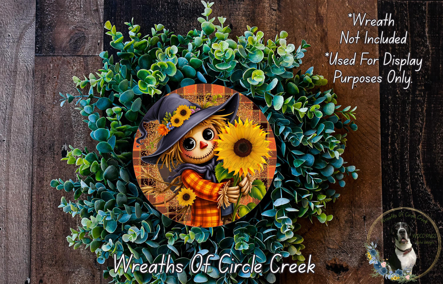 a wreath with a scarecrow and sunflowers, surrounded by greenery.