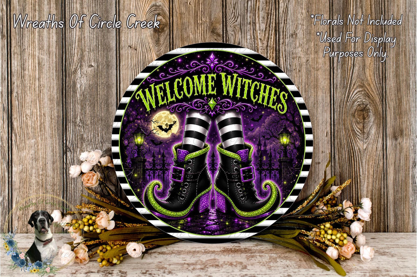 a decorative sign with the text "Welcome Witches" and a pair of witch's boots, surrounded by a floral arrangement and a wooden background.