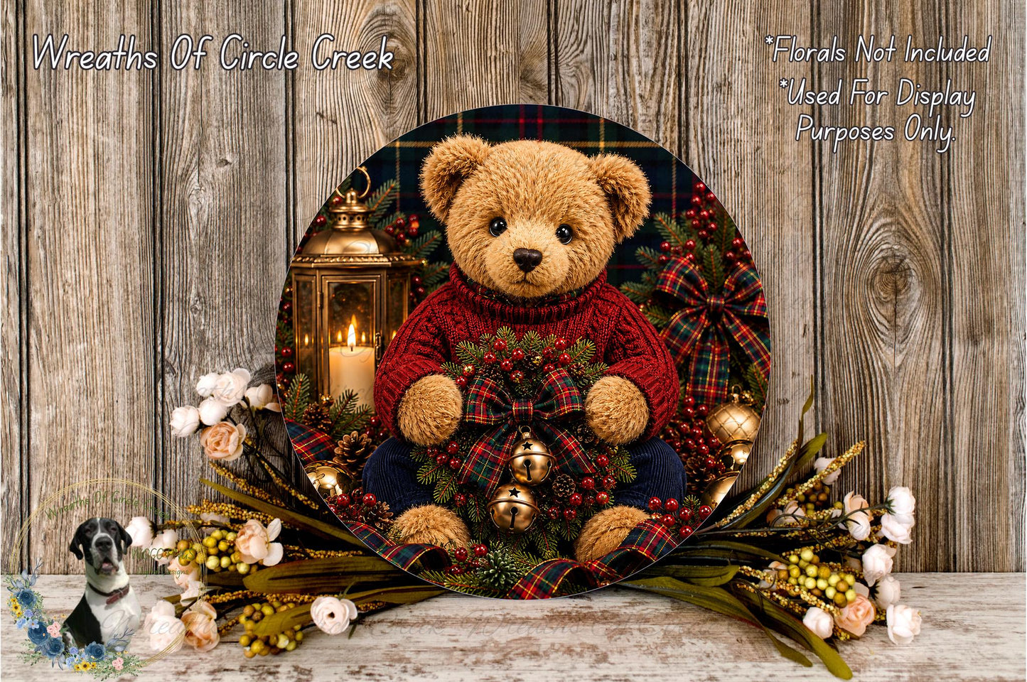 A teddy bear wearing a red sweater and holding a Christmas wreath sits on a wooden surface, surrounded by a floral arrangement and a lantern.