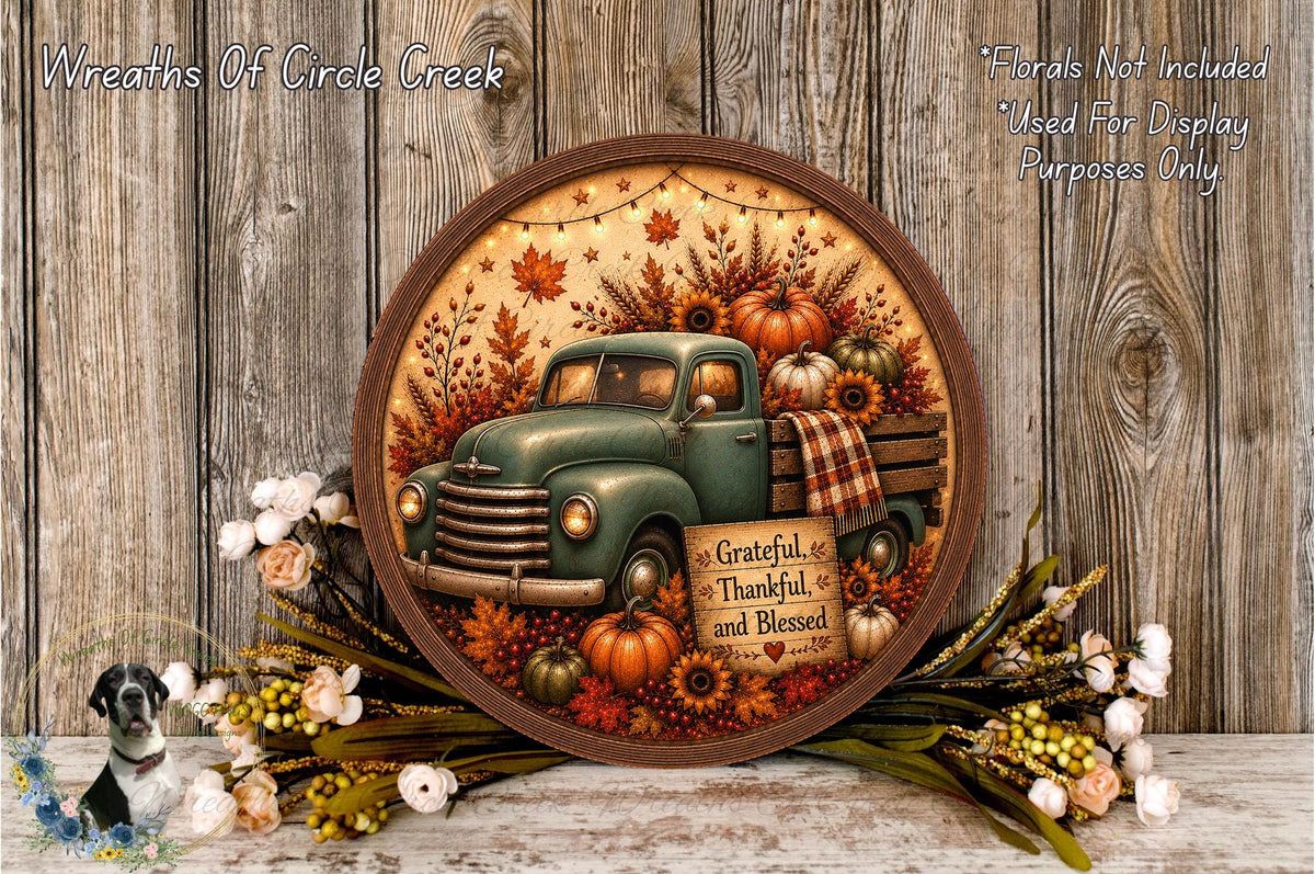 A round wooden plaque with a vintage green truck surrounded by autumn foliage, pumpkins, and flowers, with a message of gratitude and thanksgiving.