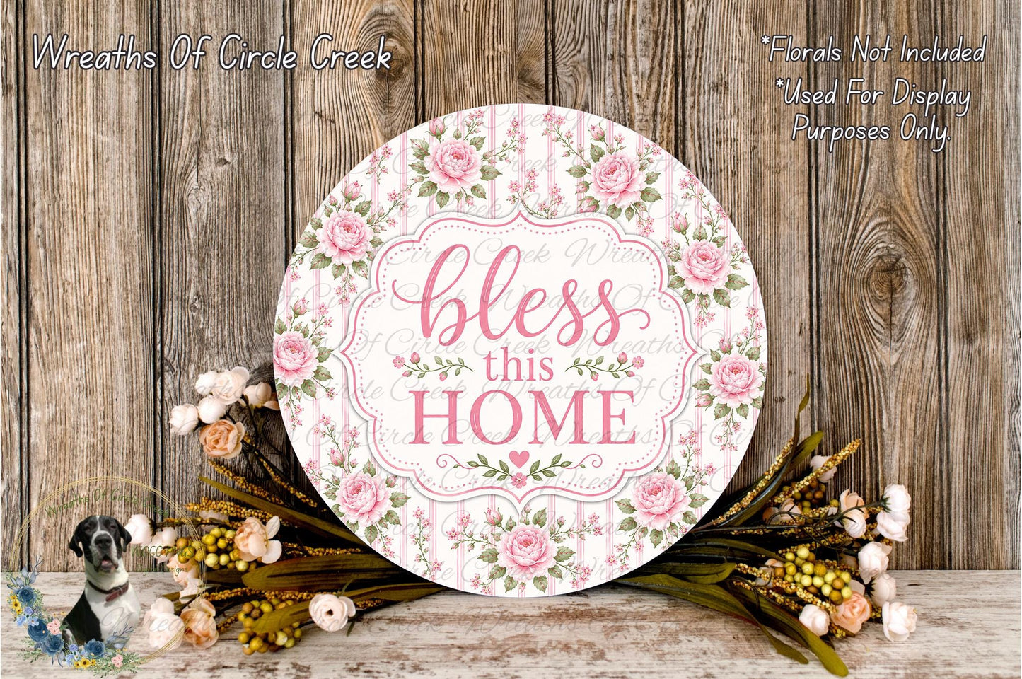 a round sign with a floral design and the text "bless this home" displayed on it, surrounded by a bouquet of flowers and greenery.