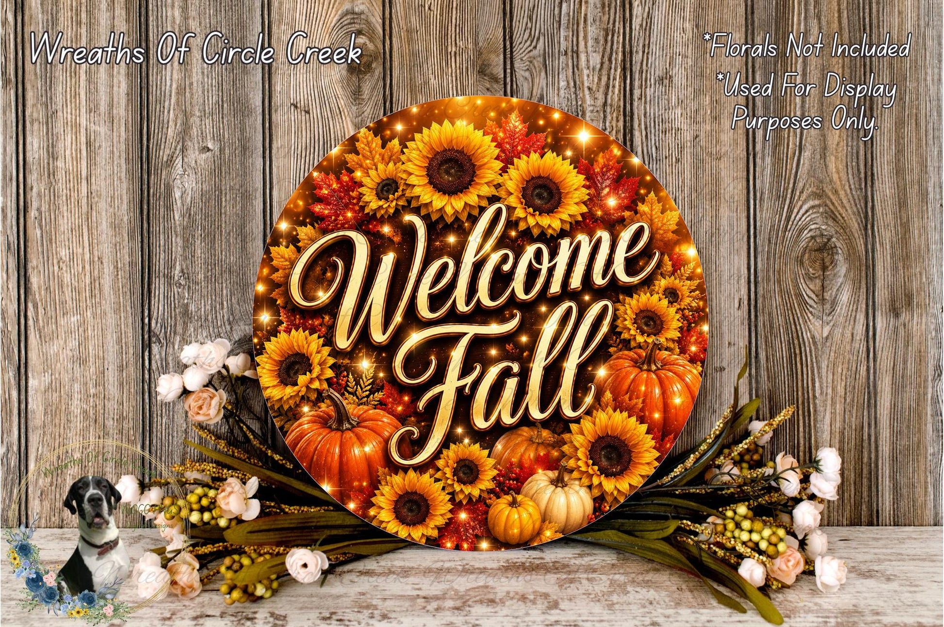 a circular sign with the text "Welcome Fall" surrounded by a floral arrangement of sunflowers, pumpkins, and other fall-themed decorations. The sign is placed on a wooden surface, and there are additional fall-themed decorations in the background.