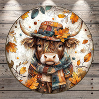 A cow wearing a colorful hat and scarf, surrounded by autumn leaves and branches, is depicted in the image.