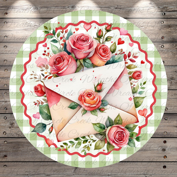 A decorative round plate with a floral design featuring pink roses and green leaves surrounding a white envelope.