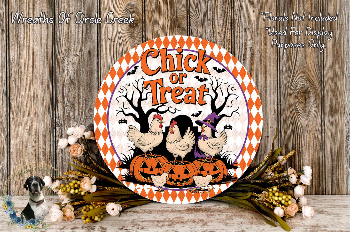 a Halloween-themed sign with a chicken and pumpkin design, surrounded by flowers and placed on a wooden surface.