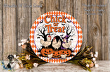 a Halloween-themed sign with a chicken and pumpkin design, surrounded by flowers and placed on a wooden surface.