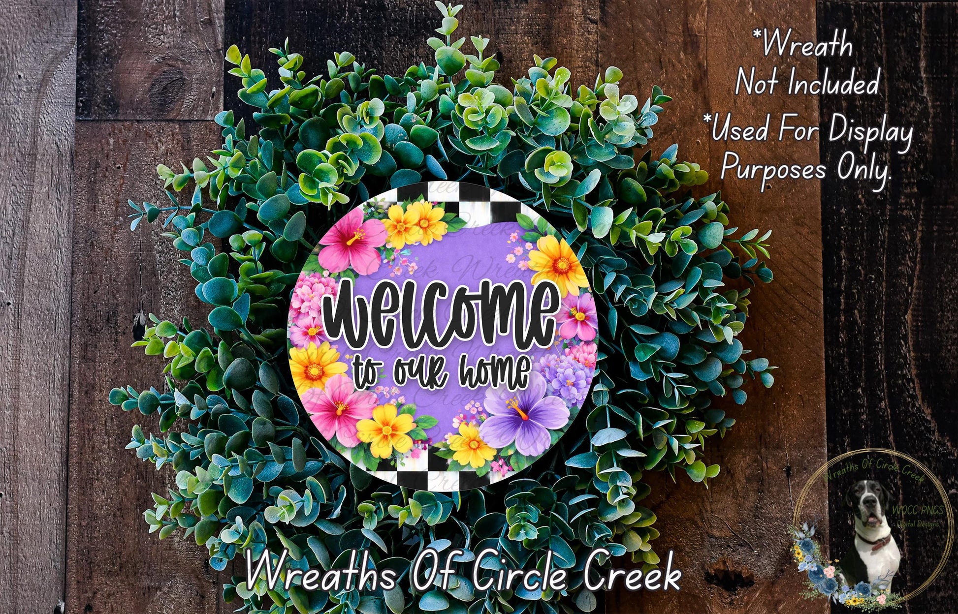 a wreath with a colorful floral design and the text "Welcome to our home" displayed on it. The wreath is made of various green and purple plants, creating a vibrant and welcoming atmosphere.