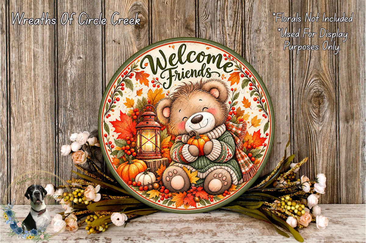 A decorative plate with a teddy bear and autumn foliage, surrounded by flowers and a lantern, against a wooden background.