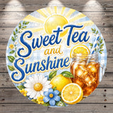 A round sign with the text "Sweet Tea and Sunshine" surrounded by various fruits and flowers, including lemon slices, daisies, and a glass of iced tea.