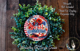a wreath made of various green plants and flowers, with a patriotic design and the text "Sweet Summertime" displayed on it.