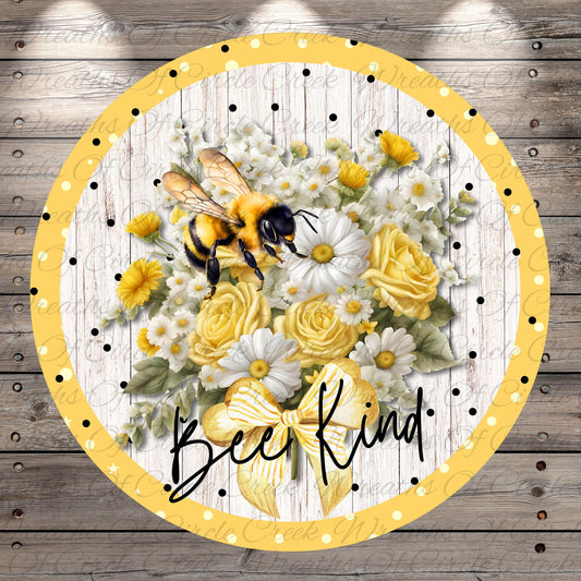 A circular frame with a yellow border and a floral arrangement of yellow and white flowers, including daisies and roses, along with a bee. The text "Bee Kind" is written in the center of the frame.