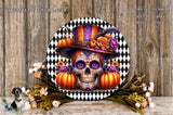 a decorative skull wearing a colorful hat, surrounded by pumpkins and flowers, with a black and white checkered border.