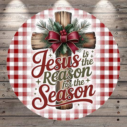 A circular Christmas-themed sign with a wooden cross and a bow of berries, surrounded by a red and white checkered pattern. The text on the sign reads "Jesus is the Reason for the Season".