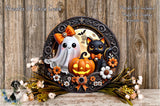 A Halloween-themed wreath featuring a ghost, a cat, a pumpkin, and flowers, with a wooden background.