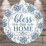 A round sign with a floral border and the text "bless this home" in blue and white.