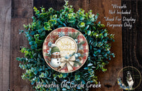 A wreath made of green foliage and a snowman, with the text &quot;Winter Wonderland&quot; displayed on it.