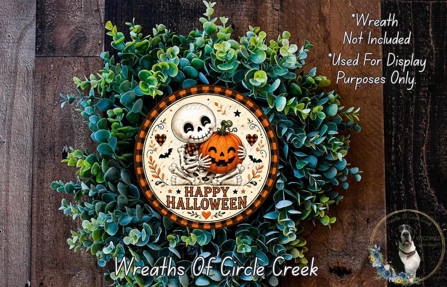 A Halloween wreath made of green plants and a skeleton holding a pumpkin, with the text "Happy Halloween" on the wreath.