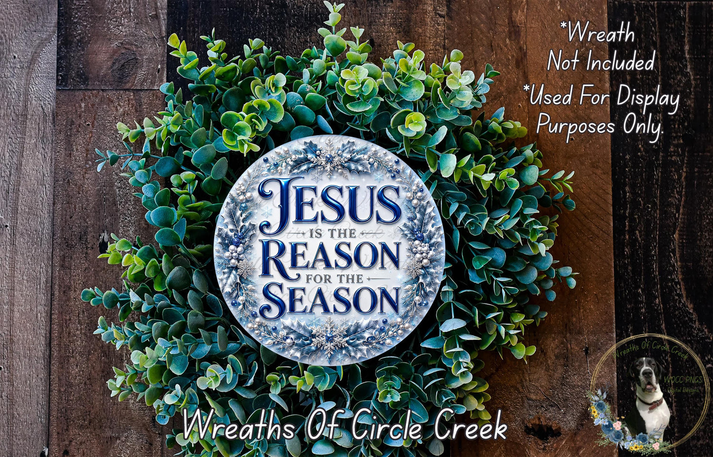 a wreath made of green leaves and a circular sign with the text "Jesus is the reason for the season" on it, placed on a wooden surface.