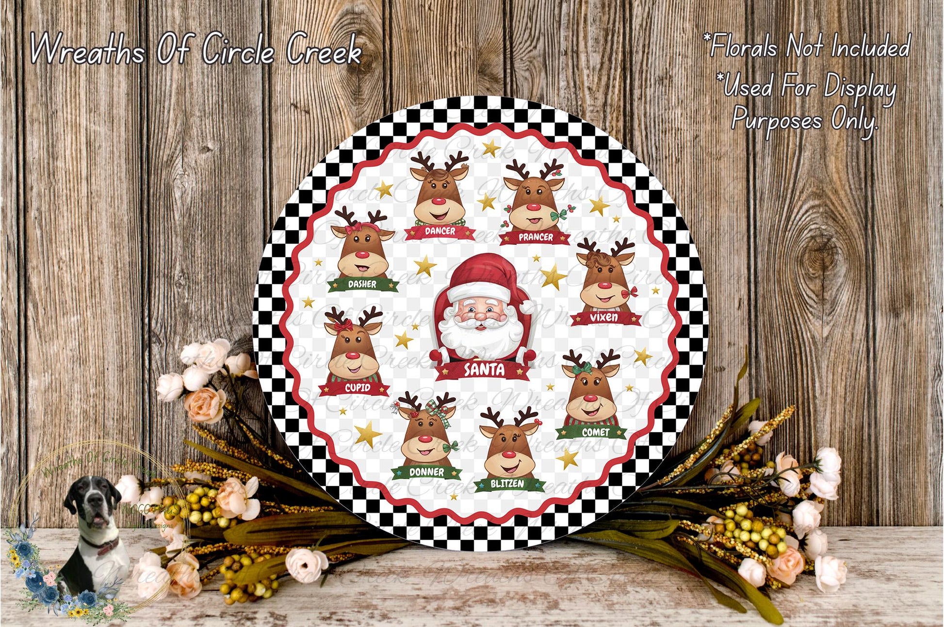 A festive Christmas-themed wreath with a Santa Claus face, surrounded by reindeer and flowers, placed on a wooden surface.