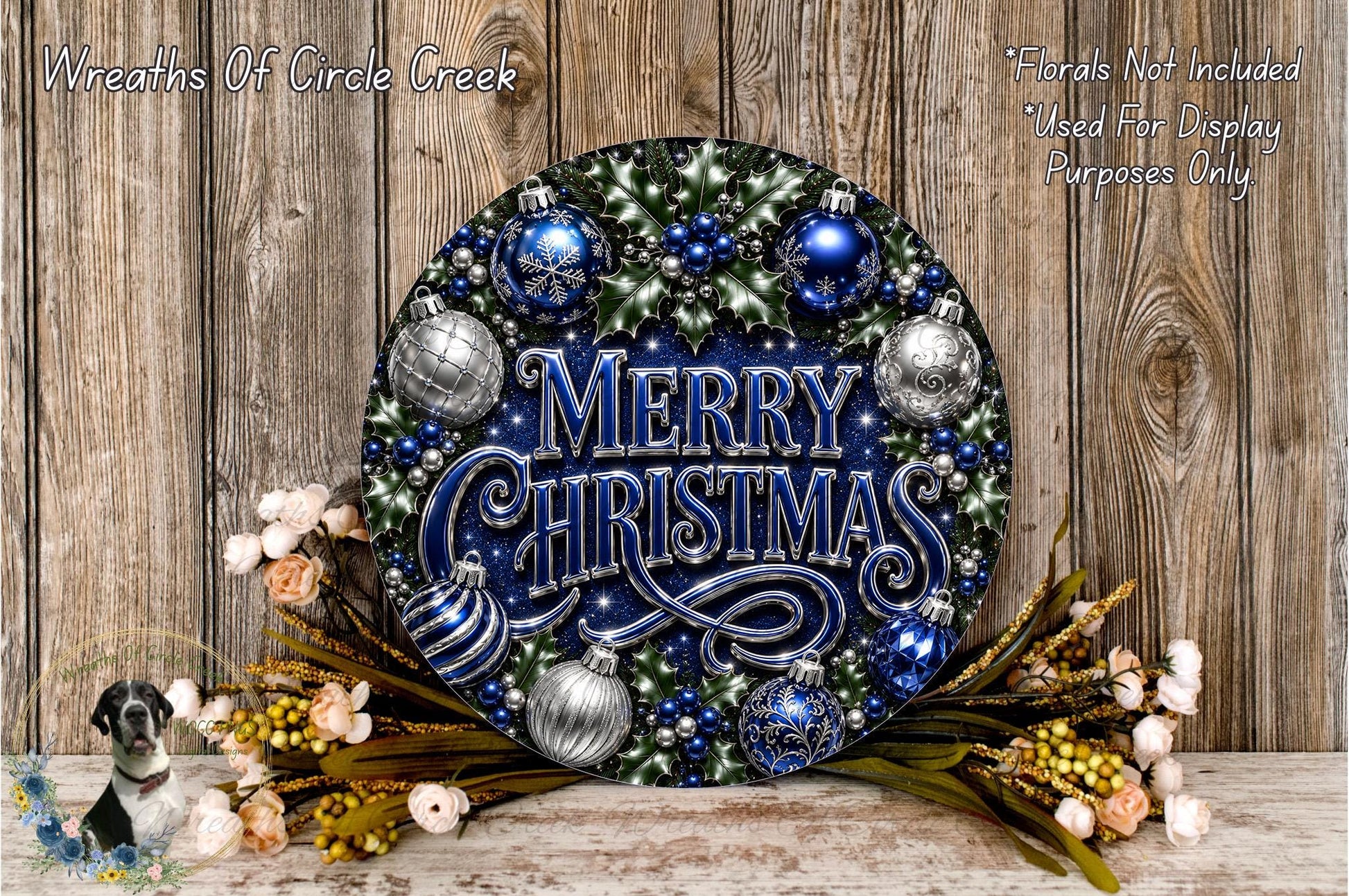 A festive wreath with the text "Merry Christmas" displayed prominently, surrounded by various ornaments and flowers. The wreath is set against a rustic wooden background.