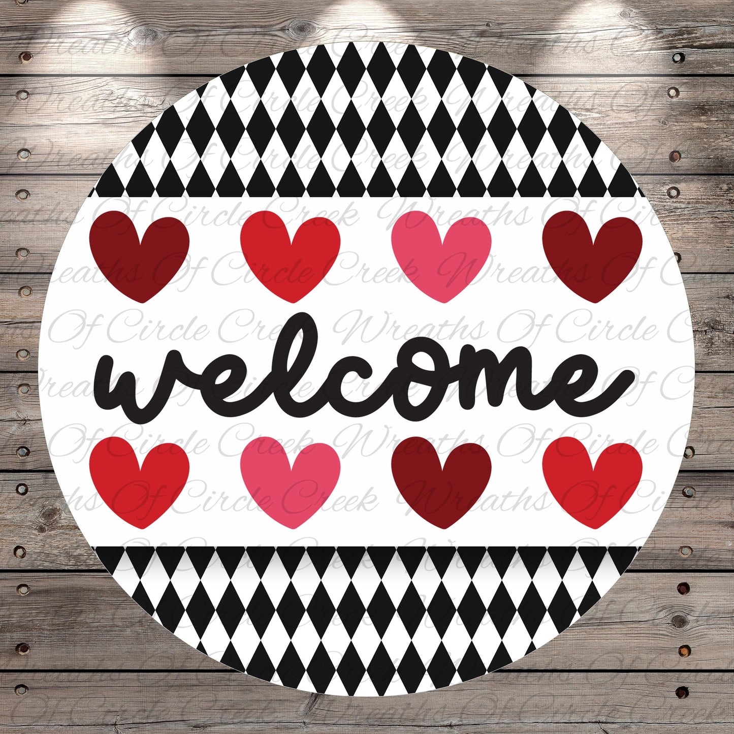 A circular sign with the word "welcome" written in cursive, surrounded by a pattern of red and pink hearts.