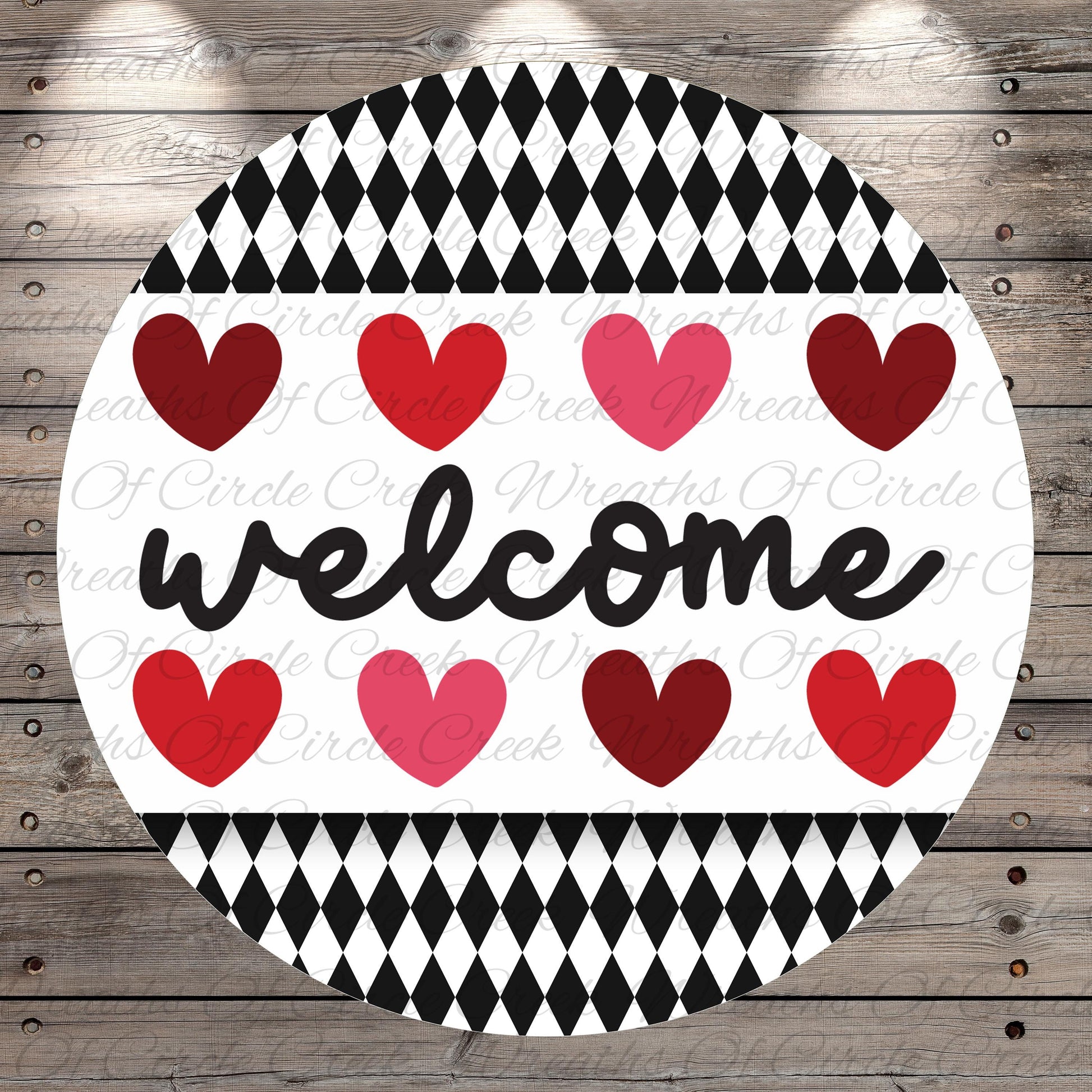 A circular sign with the word "welcome" written in cursive, surrounded by a pattern of red and pink hearts.