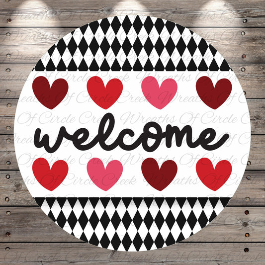 A circular sign with the word "welcome" written in cursive, surrounded by a pattern of red and pink hearts.