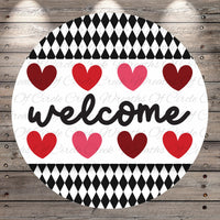 A circular sign with the word "welcome" written in cursive, surrounded by a pattern of red and pink hearts.