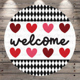 A circular sign with the word "welcome" written in cursive, surrounded by a pattern of red and pink hearts.