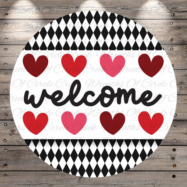 A circular sign with the word "welcome" written in cursive, surrounded by a pattern of red and pink hearts.