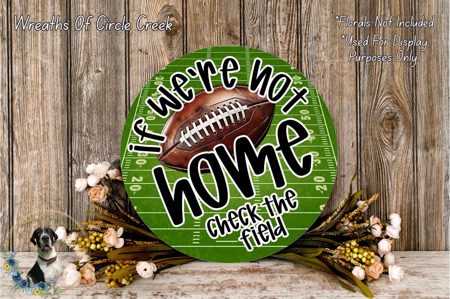 a green football field sign with the text "If we're not home, check the field" displayed on it. The sign is surrounded by a floral arrangement and a wooden background.