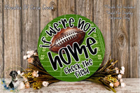 a green football field sign with the text "If we're not home, check the field" displayed on it. The sign is surrounded by a floral arrangement and a wooden background.