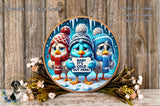 A decorative plate featuring three cartoon birds wearing winter hats and scarves, holding a sign that says "Baby It's cold here!" The plate is set against a snowy background and is surrounded by flowers.