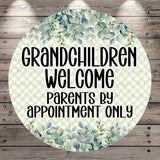 A circular sign with a green leafy pattern and text that reads "GRANDCHILDREN WELCOME PARENTS BY APPOINTMENT ONLY".