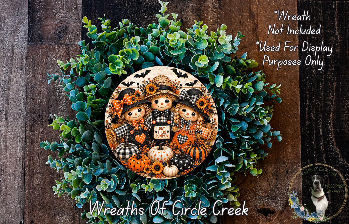 a wreath with a group of three scarecrow dolls, each holding a sign that says "Hey Pumpkin". The wreath is made of green foliage and has a wooden background.