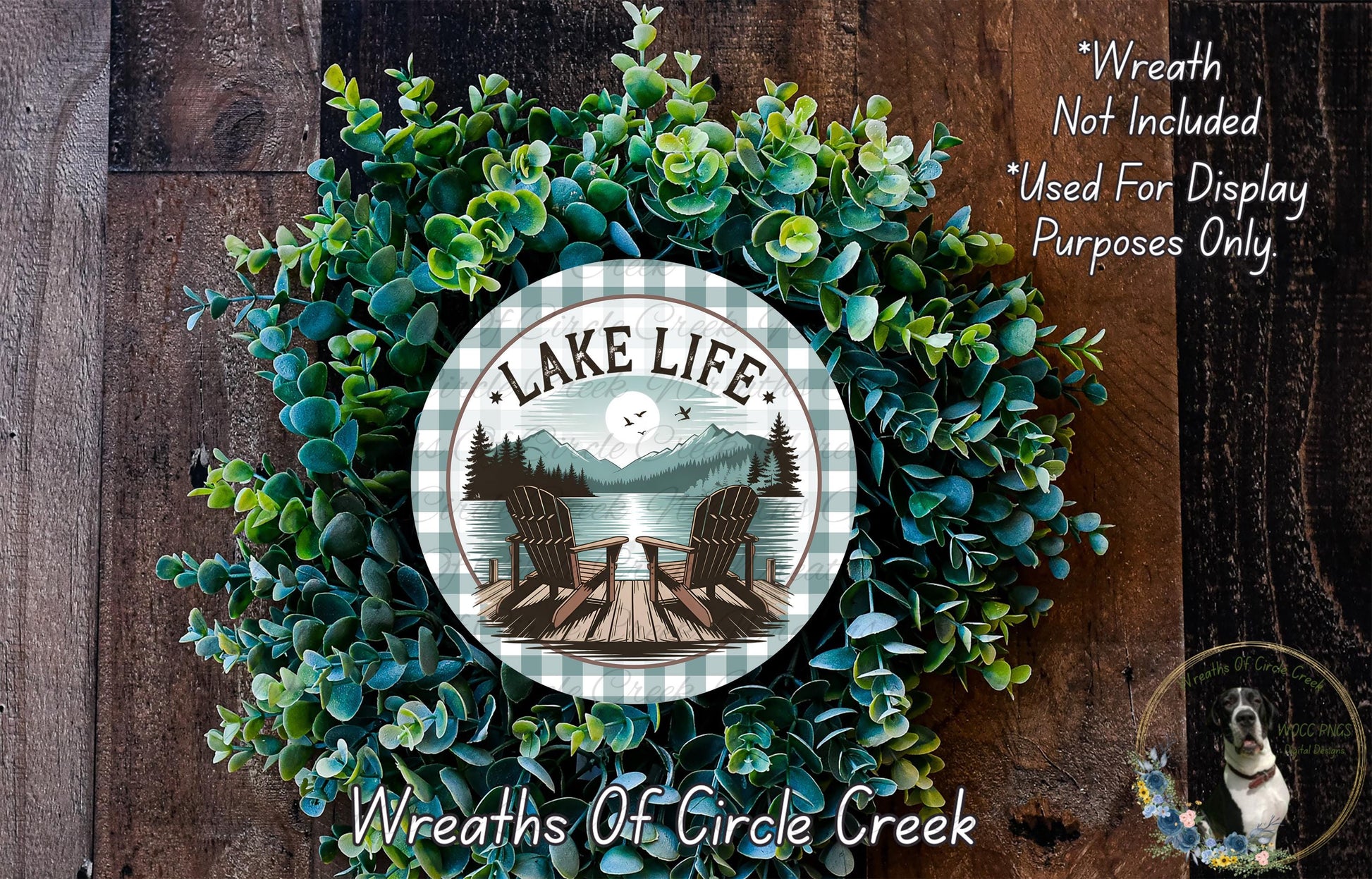 A wreath made of green foliage and a circular sign with the text "Lake Life" and an image of a lake and chairs.