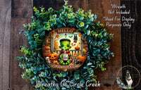 A wreath featuring a spooky green monster with a friendly greeting, surrounded by autumn-themed decorations such as pumpkins and a skeleton.
