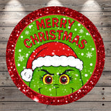 A circular Christmas-themed design featuring a grumpy-looking green creature wearing a Santa hat, surrounded by snowflakes and the text "MERRY CHRISTMAS".