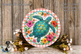 a round, decorative plate with a vibrant illustration of a turtle surrounded by a colorful floral arrangement. The plate is placed on a wooden surface, and there are also some flowers and greenery nearby.